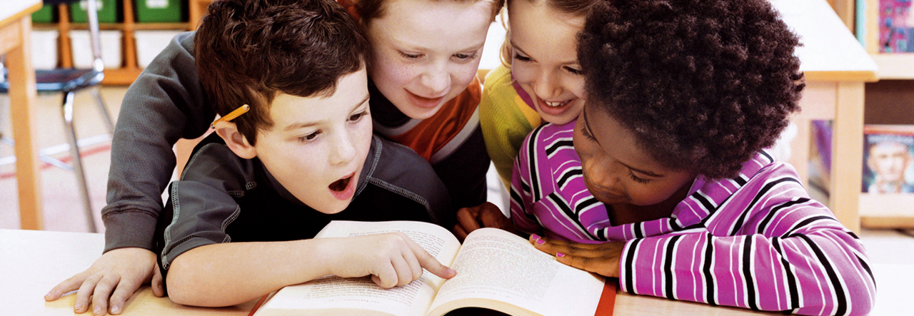 Crianças na escola lendo livro juntas