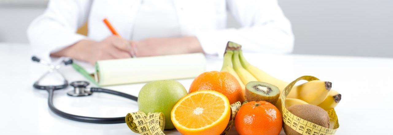 Nutricionista em sua mesa mostra alimentos voltados para ingestão saudável