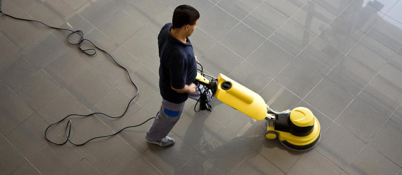 Homem higieniza o chão com máquina de limpeza