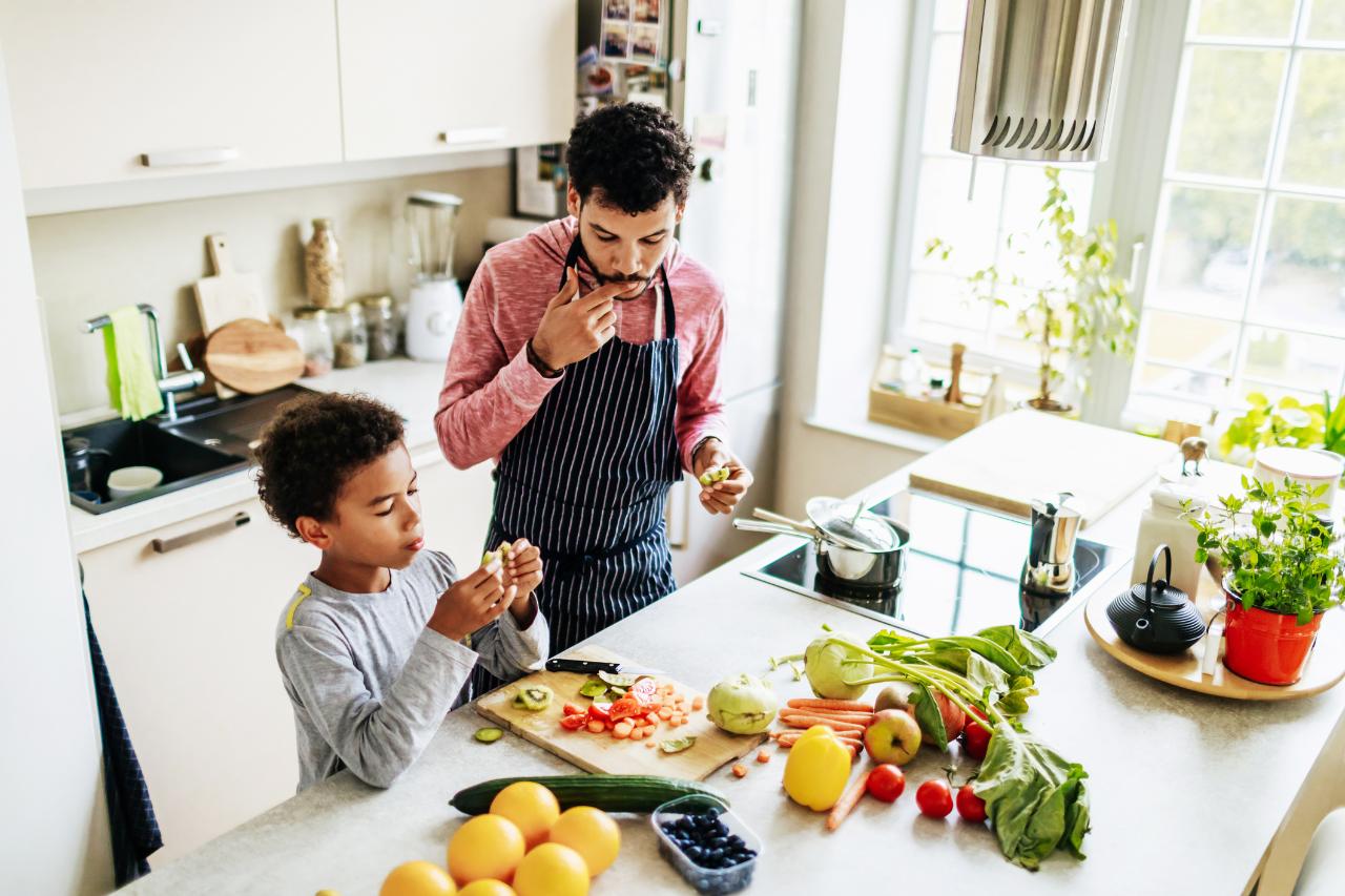 Pai e criança cozinham alimentos saudáveis