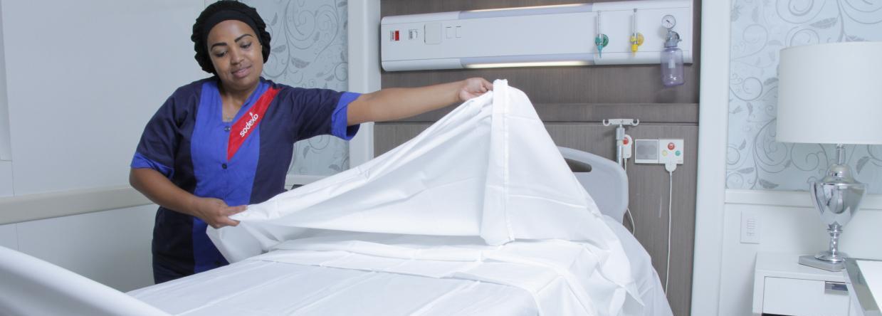 Colaboradora Sodexo realiza função de manutenção e limpeza em ambiente de quarto hospitalar