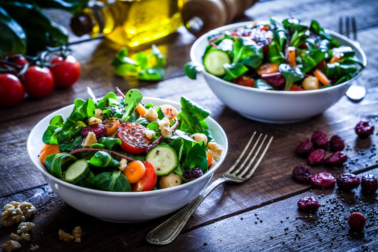 Mesa com diversos legumes, frutas e vegetais simbolizando a alimentação saudável